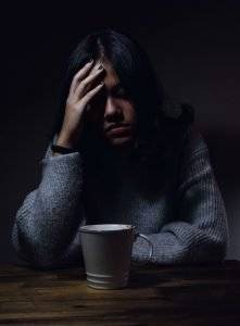 woman sitting in the dark stressed about pending criminal charges