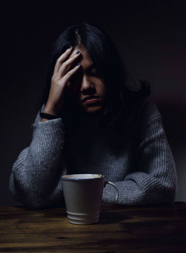 A Domestic Violence Lawyer Can Help You 22 woman sitting in the dark stressed about pending criminal charges